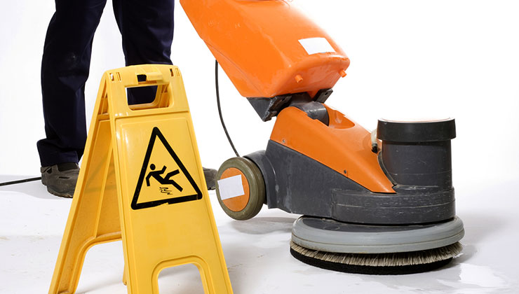 Worker using a floor cleaning machine.